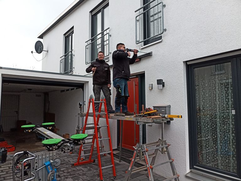 Mitarbeiter montieren Vordachhalterung